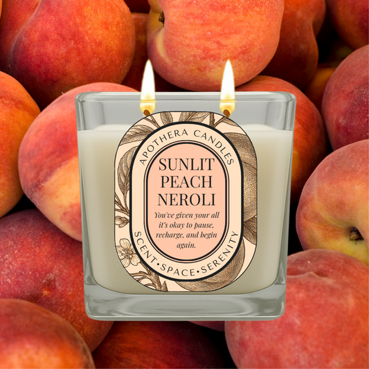 Lit Sunlit Peach Neroli candle by ApoThera set against a background of fresh peaches, capturing the essence of a warm, fruity, and calming self-care ritual.