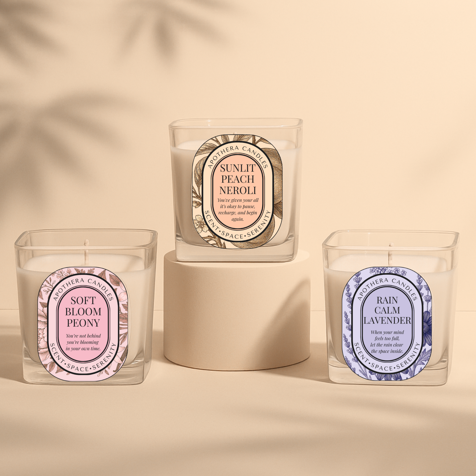 ApoThera’s Rebalance Ritual Collection featuring three signature candles—Soft Bloom Peony, Sunlit Peach Neroli, and Rain Calm Lavender—presented in a minimal, serene display.